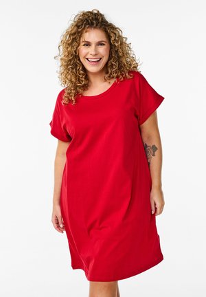 Punainen lyhythihainen mekko, joka on valmistettu pehmeästä puuvillasta. Siinä on pyöreä pääntie, rento malli ja hienovarainen tekstuuri. Ei näkyviä kuvioita tai varusteita.