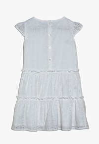 Biała sukienka z tkaniny z dziurkowanym wzorem dla dziewczynek, z krótkimi rękawami, zapinana na guziki z tyłu, z falbanami na spódnicy.