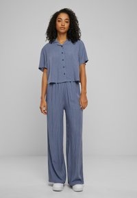 Two-piece outfit featuring a short-sleeved, button-up top with a cropped hem and wide-leg pants, in blue with vertical white stripes.