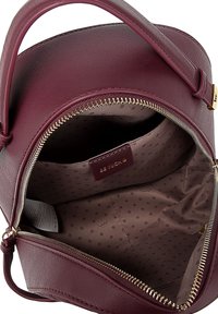 Burgundy leather handbag with a zip closure, featuring a smooth texture and a polka-dotted fabric lining. Interior has a brand label.