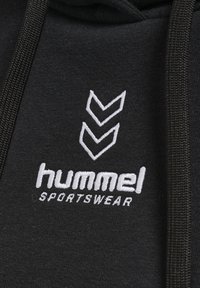 Felpa nera con cappuccio caratterizzata da un logo ricamato bianco "hummel" e tre strisce a chevron. Il materiale sembra morbido con una finitura testurizzata.