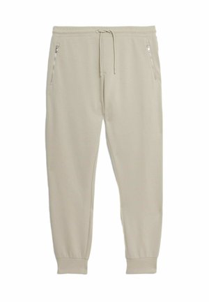 Pantaloni jogger beige realizzati in tessuto morbido, con vita regolabile tramite cordoncino, tasche laterali con zip e polsini affusolati alla caviglia.