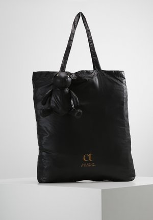 Black tote bag with long handles, featuring a small attached black teddy bear and gold "et Day Birger et Mikkelsen" logo.