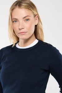 Dunkelblaues, geripptes Sweatshirt mit rundem Ausschnitt, das drei dekorative schwarze Knöpfe an der linken Schulter aufweist, aus einem weichen Strickstoff gefertigt.