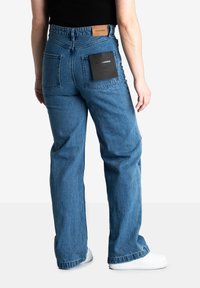 Denim jeans in medium blue met een hoge taille, rechte pijpen, twee achterzakken en een tan leren label op de tailleband.