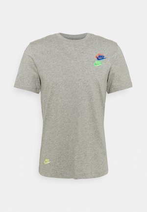 T-shirt gris clair à manches courtes et col rond avec trois petits logos colorés Nike sur la poitrine et un près de l’ourlet inférieur.