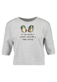 Camiseta gris de corte corto con mangas de tres cuartos, que presenta dos piñas de lentejuelas y el texto "SI FUERAS UNA FRUTA, SERÍAS UNA PIÑA EXCELENTE."