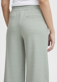 Lichtblauwe geruite wijde broek met een ontspannen pasvorm, met een elastische tailleband en een enkele achterzak. Gladde textuur.