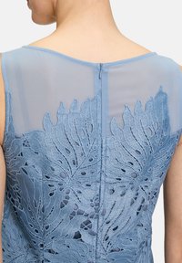 Blaues besticktes Kleid mit komplizierten Blattmustern, transparenter Überlagerung und Reißverschluss im Rücken. Weicher Stoff mit geschichtetem Detail.