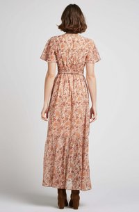 Robe longue fleurie en tissu doux et léger. Elle présente un ourlet en couches, des manches courtes, et une taille ajustée avec un motif délicat dans des tons chauds.