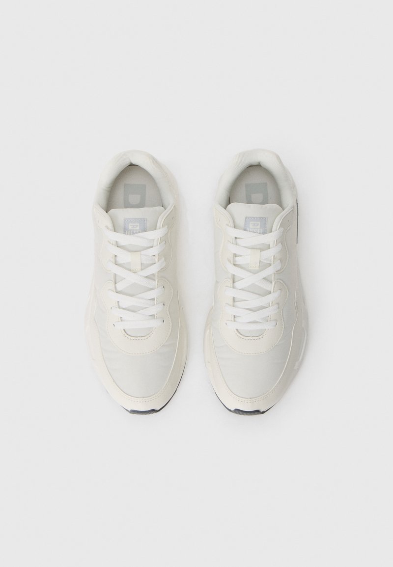Zapatillas blancas con un upper sintético suave, punta redonda, suela gruesa y cordones planos blancos. Incluyen un collar acolchado y un logo discreto.