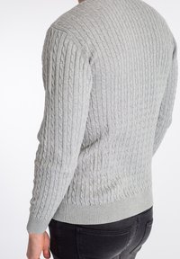 Szary sweter w sploty z dzianiny, z prążkowanymi mankietami i krawędzią, wykazujący teksturowany wzór i dopasowany krój, pokazany od tyłu.