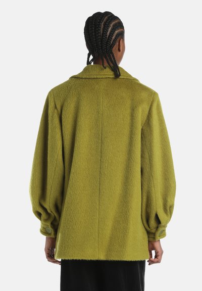 Groene oversized jas van gestructureerde stof, met een kraag, elastische boorden en een op maat gemaakte achternaad.