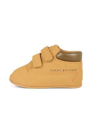 Scarpa per bambini in pelle color tan con una texture morbida, due cintura in velcro e un accento in pelle marrone sul tallone. Presenta il logo Tommy Hilfiger.