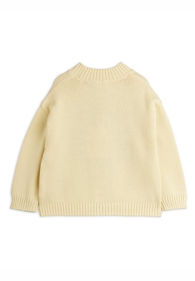 Suéter de punto color crema con un cuello redondo acanalado, mangas largas y puños y dobladillo acanalados. Textura suave y ajuste holgado.