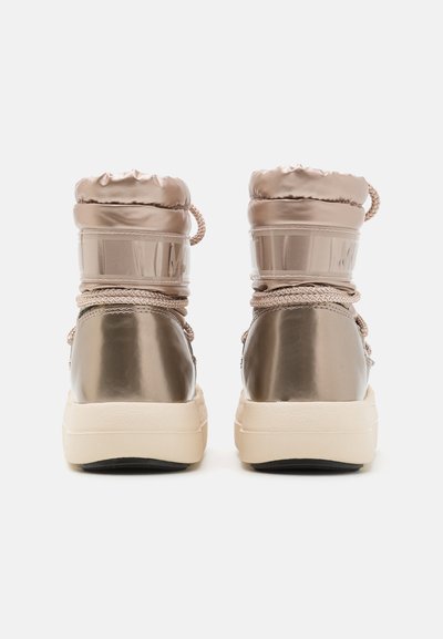 Metallic beige ankelstövlar med vadderad krage, texturerade skosnören och en kontrasterande krämfärgad gummisula. Slät yta, minimalistisk design.