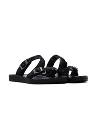 Zwarte sandalen met gemêleerde banden, voorzien van decoratieve studs en verstelbare gespen. Platte zolen zorgen voor stabiliteit en comfort.