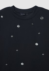 Marineblaue Baumwoll-T-Shirt mit metallischen, kreisförmigen Nieten in verschiedenen Größen, die zufällig über die Vorderseite verteilt sind. Rundhalsausschnitt, lockere Passform.