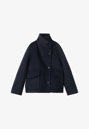 Granatowa wełniana kurtka z wysokim kołnierzem, zapięciem na guziki z przodu oraz dwoma dużymi naszywanymi kieszeniami z przodu. Gładka faktura, luźny krój.