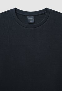 Maglietta nera a maniche lunghe realizzata in tessuto strutturato. Presenta un collo rotondo e un'etichetta con "CALLIOPE" in bianco e la taglia "L."