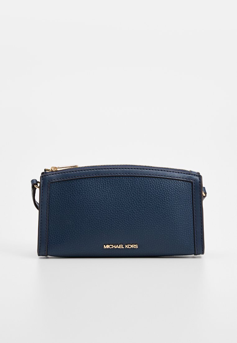Pochette en cuir texturé bleu marine avec un dessus arrondi, matériel doré et logo "Michael Kors" sur le devant. Fermeture à glissière avec une bandoulière amovible.
