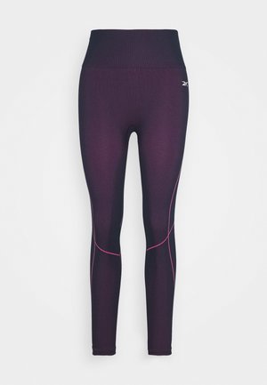 Leggings taille haute en tissu violet foncé à la texture lisse. Présentent des coutures d'accent rose et une silhouette ajustée.