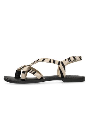 Platte sandaal met zwarte zool en beige bandjes met zwarte zebrastripes, teenlus en verstelbare zijgesp.