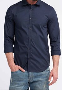 Marineblauwe overhemden met lange mouwen en een puntige kraag, van een gladde stof en met een afgeronde zoom. Te combineren met lichtblauwe denim jeans.