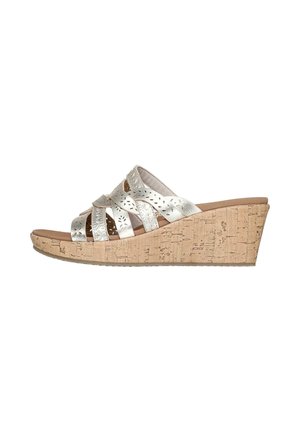 Sandalias de cuña plateadas con suela de corcho y diseño de correas cruzadas. Presenta detalles troquelados en las correas y una plantilla acolchada para mayor comodidad.