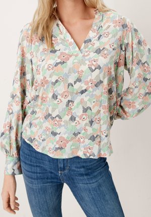 Blouse florale en tissu léger avec des motifs pastel rose, vert et bleu, décolleté en V et manches longues bouffantes.