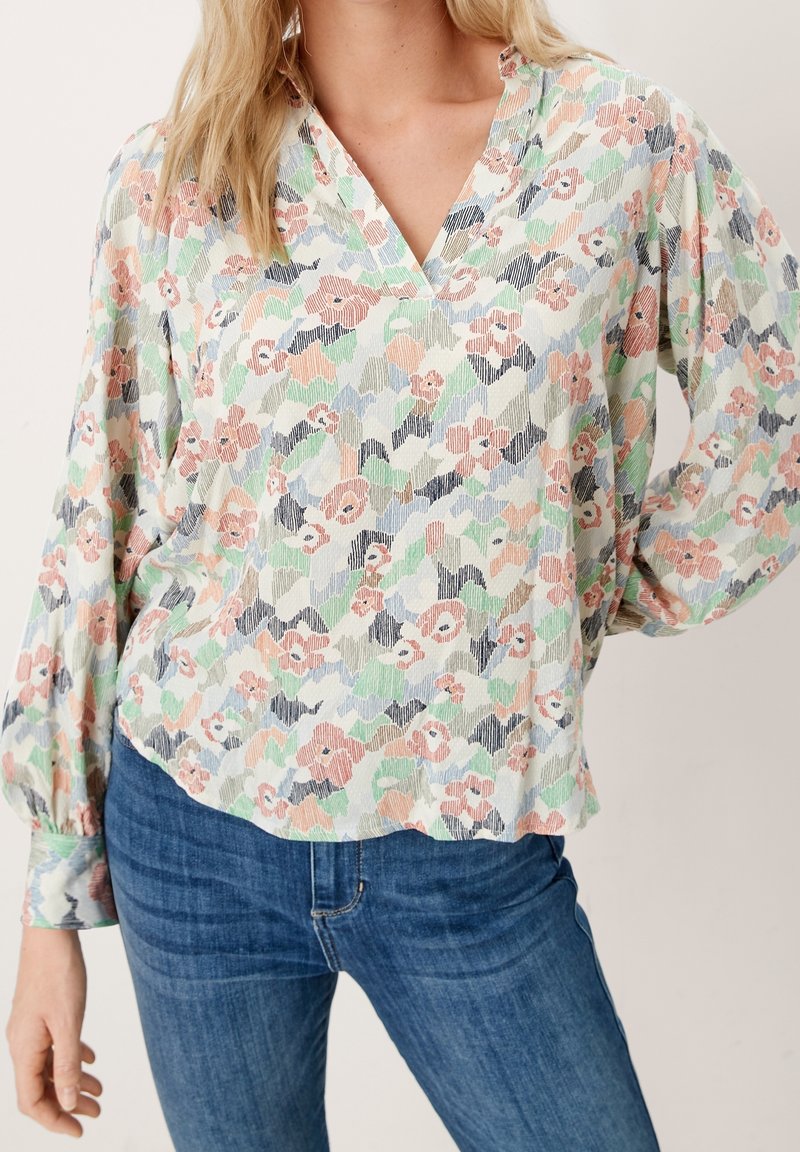 Blusa floreale in tessuto leggero con motivi in rosa pastello, verde e blu, design a scollo a V e maniche lunghe a sbuffo.