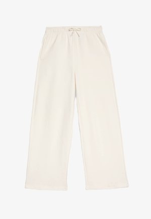 Pantaloni da jogging larghi di colore beige chiaro, realizzati in tessuto morbido. Presentano un elastico in vita con cordino e due tasche laterali.