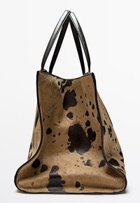 Grande borsa tote realizzata in pelliccia marrone con motivi a macchie nere. Presenta rifiniture in pelle nera e doppie tracolle. Design con apertura superiore.