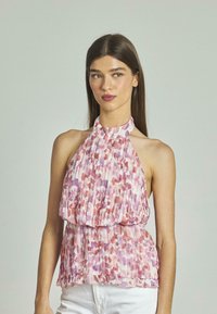 Halter-neck Top aus leichtem, plissiertem Stoff mit einem abstrakten Muster in Pink und Lila. Verfügt über eine geraffte Taille und einen Rüschensaum.