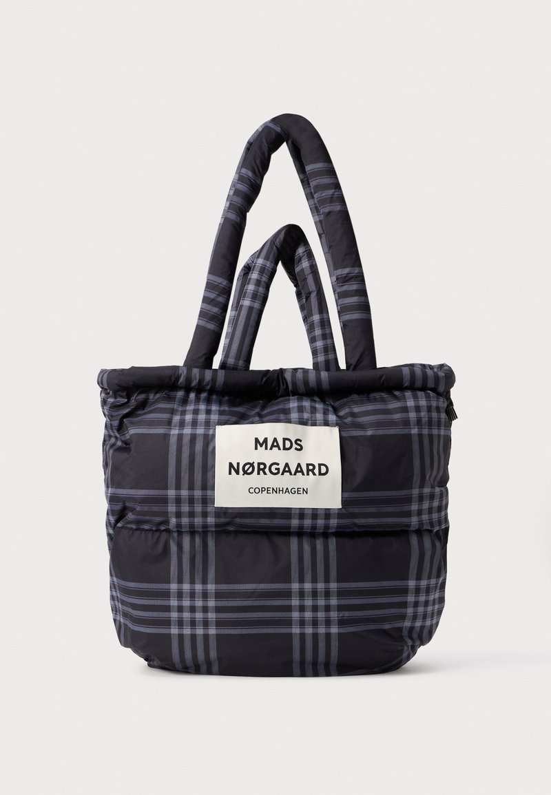 Black and gray plaid tote bag with quilted texture, dual top handles, and a label displaying "MADS NØRGAARD COPENHAGEN." Lightweight design.