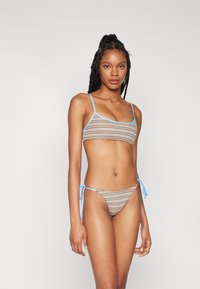 Brun og lyseblå stripete bikini med tynne blå stropper, med trekant-topp og knytteside-bunn, laget av elastisk stoff.