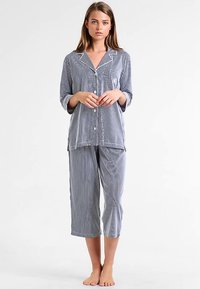 Stripete pysjamasett med knapper i marineblått og hvitt. Mykt stoff med en lett følelse. Har krage, lange ermer og korte bukser.