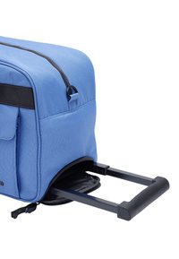 Niebieski plecak z tkaniny, z zamkami, wydłużanym uchwytem i czarnymi akcentami. Posiada gładką teksturę i praktyczny design, który ułatwia mobilność.