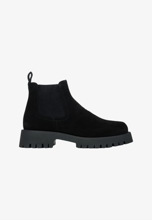 Czarne zamszowe botki za kostkę z elastycznymi panelami bocznymi, okrągłym noskiem, masywną szaro-skalną podeszwą i pętelką z tyłu ułatwiającą zakładanie.