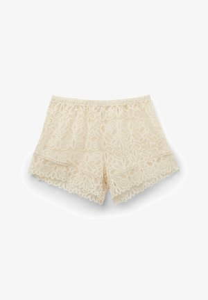 Spetsshorts i ljust beige med elastisk midja, med blommönster och vågiga kanter längs fållen för extra detalj.