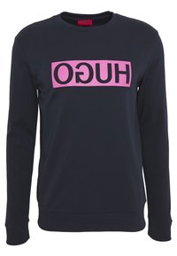 Mörkblå långärmad sweatshirt med en rosa rektangulär logga som har omvänd svart text "HUGO" på bröstet.