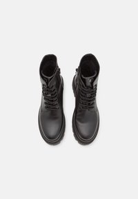 Bottes noires en cuir à hauteur de cheville avec une finition lisse, un design à lacets, des fermetures éclair latérales et une semelle en caoutchouc texturée.