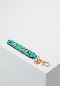 Un portachiavi in finta pelle turchese con scritta dorata "ALDO", gancio a moschettone e ciondolo decorativo dorato.