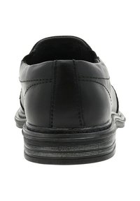 Chaussure habillée en cuir noir avec un bout arrondi, un design épuré, des coutures visibles et une semelle stratifiée comportant des rainures horizontales.