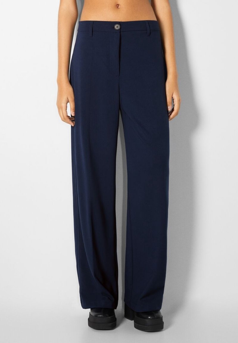 Námořnicky modré široké kalhoty vyrobené z hladké látky, s předním zapínáním na knoflík, plochým předním dílem a rovnou siluetou.