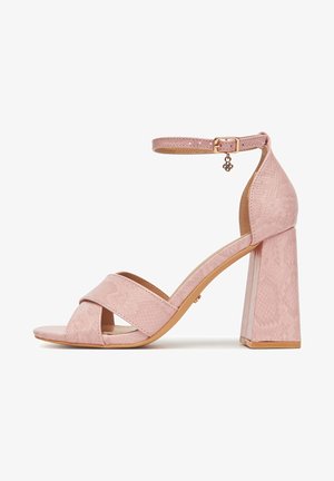 Sandalo rosa con tacco alto, cinturino alla caviglia, tacco a blocco e fasce incrociate sulla parte anteriore con un motivo sottile e strutturato.
