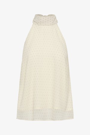 Αμάνικη μπεζ μπλούζα με ψηλό γιακά και μικρές μαύρες πουά, φτιαγμένη από ελαφρύ, ελαφρώς διαφανές ύφασμα.