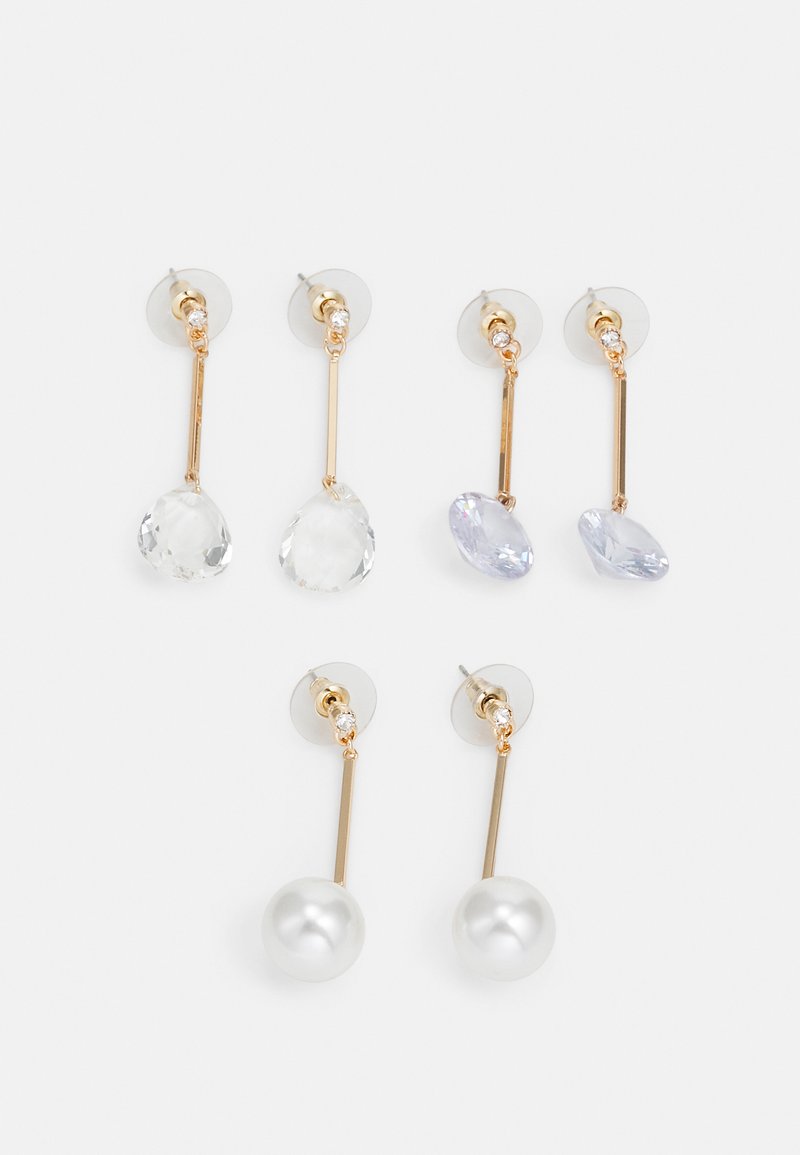 Three pairs of gold-tone drop earrings with clear and pale purple stone accents, featuring long straight bars and round pearl details.