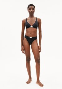 Ensemble de bikini noir composé d'un bralette triangulaire avec des bretelles réglables et un bas taille haute assorti, tous deux avec un minimum de détails de marque.