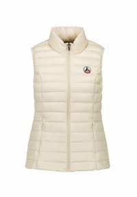 Gilet rembourré beige avec un col montant, une fermeture éclair à l'avant et des poches latérales. Présente un petit logo sur la poitrine et une texture matelassée.